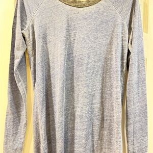 Blue long sleeve shirt with black around neck . Open in back